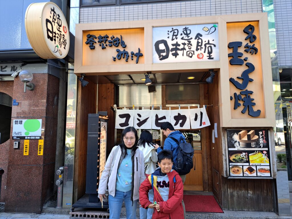日本橋浪速食堂門口,老婆與穿著紅外套的兒子準備進店享用越光米釜飯